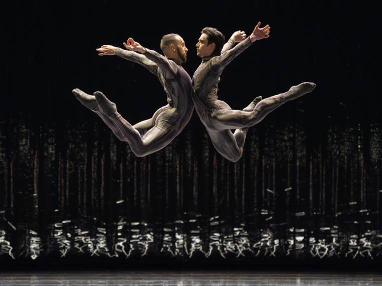 Zwei Balletttänzer springen sich an.