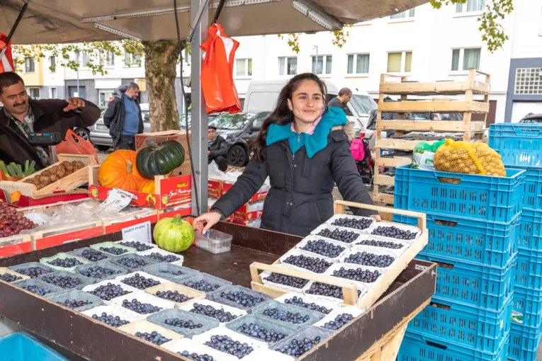 Eine junge Frau bietet Blaubeeren an.