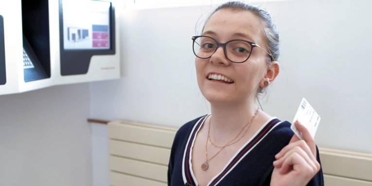 Frau mit Chipkarte in der Hand.