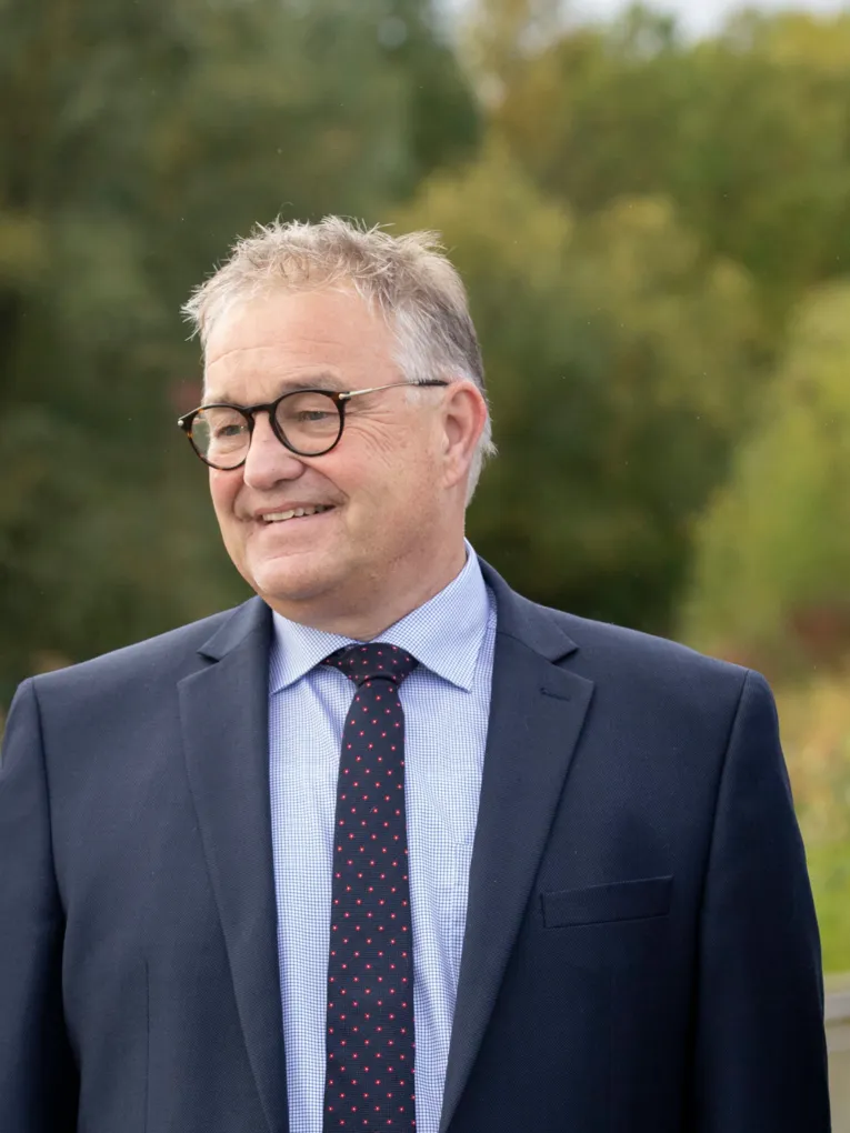 Hauke Jagau vor einem gr&uuml;nen Hintergrund im Freien.