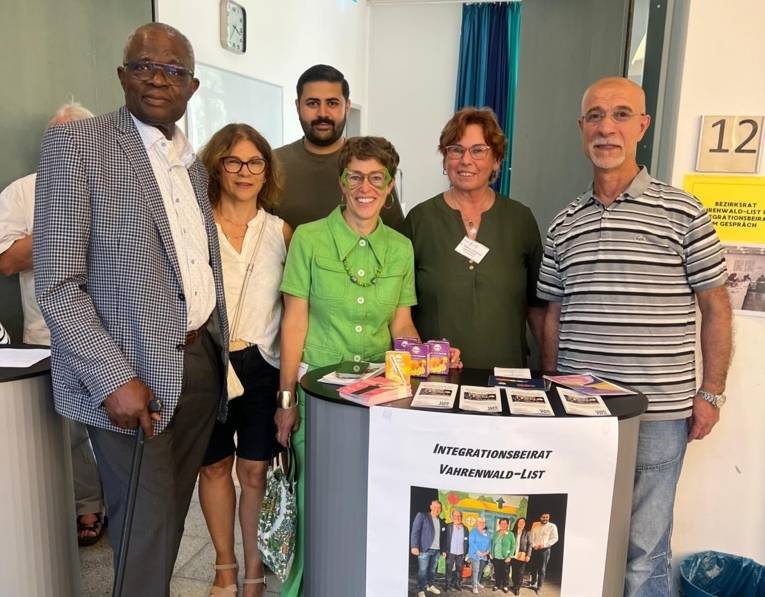 fünf Mitglied des I-Beirats hinter ihrem Infotresen im Freizeitheim Vahrenwald