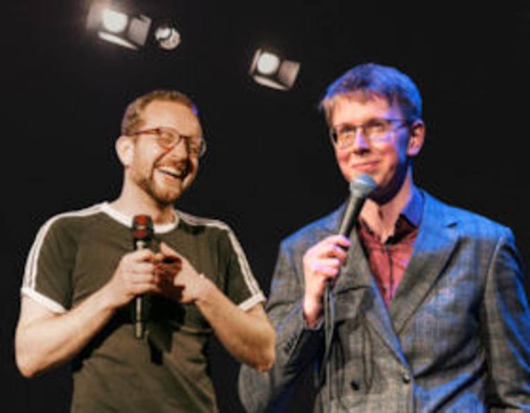 Zwi lachende Männer mit Mikros