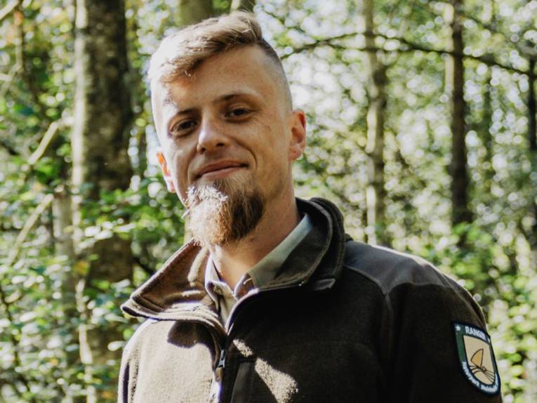 Ein Mann steht drau&szlig;en am Steinhuder Meer. Er tr&auml;gt eine Fleece-Jacke mit der Aufschrift "Naturpark Ranger".