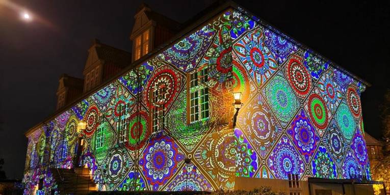 Die Fassade von Schloss Landestrost wird farbig und mit Mustern angeleuchtet.