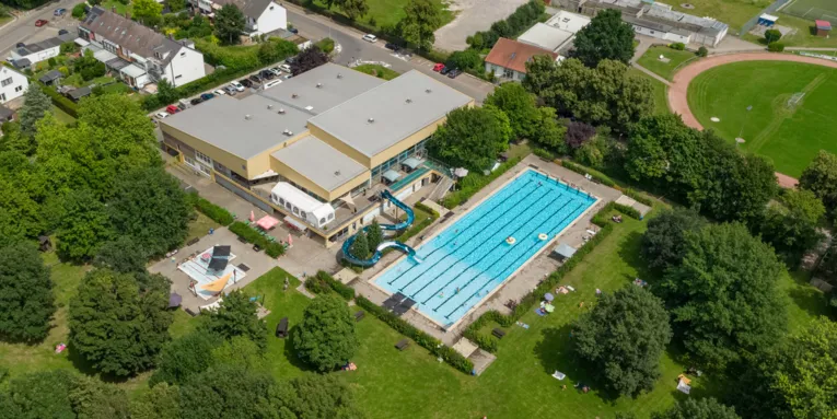 Luftbild von Schwimmhalle, Aussenbecken und Freigelände