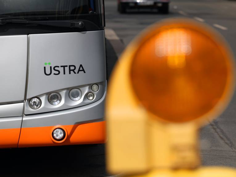 Eine Bake steht zur Markierung vor einem Bus