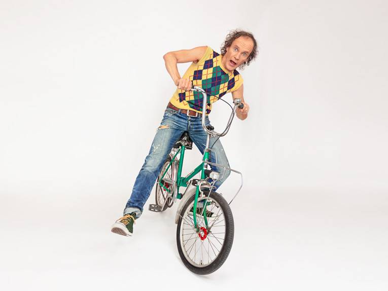 Der Dresdner Comedian Olaf Schubert auf einem Fahrrad