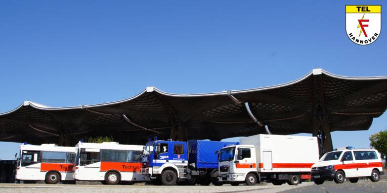 Fünf große Fahrzeuge im Freien unter einem Dach