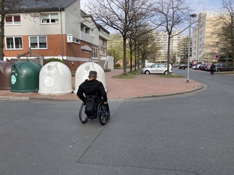 Glascontainer neben einem abgesenkten Bordstein