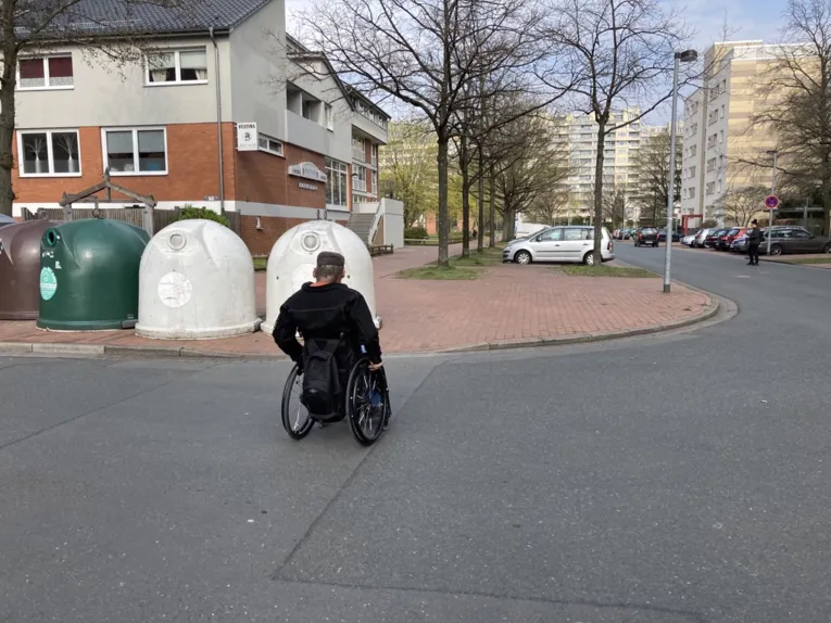 Glascontainer neben einem abgesenkten Bordstein