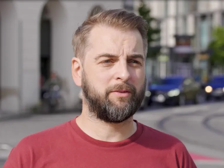 Ein Mann, der in eine Kamera spricht.