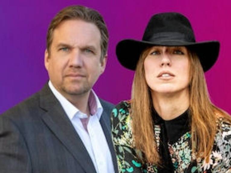 Ein Mann mit kurzem Haar in Hemd und Jackett und eine Frau mit langem Haar und Cowboyhut