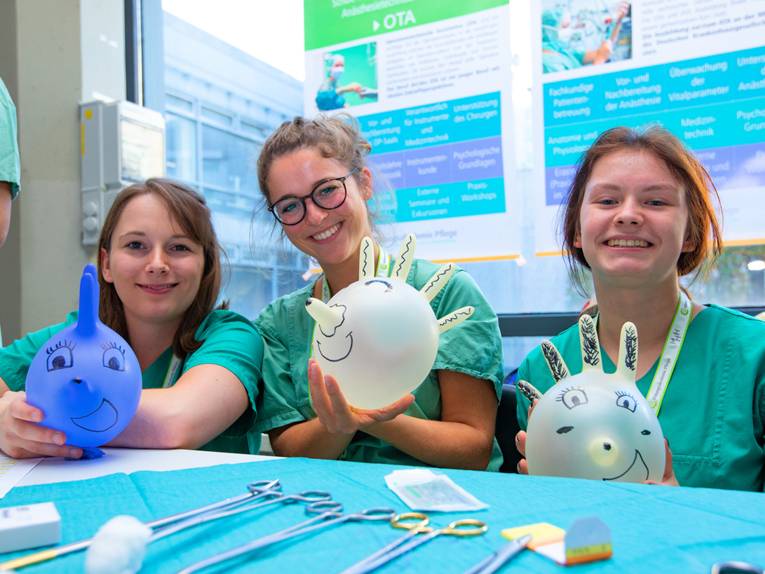 Drei junge Frauen in Klinik-Kleidung.