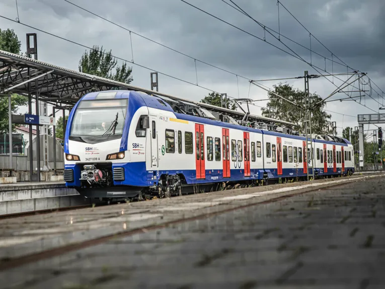 Eine blau-weiße S-Bahn steht an einem Bahnsteig.