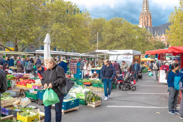 Kundschaft l&auml;uft auf dem Wochenmarkt Mitte.