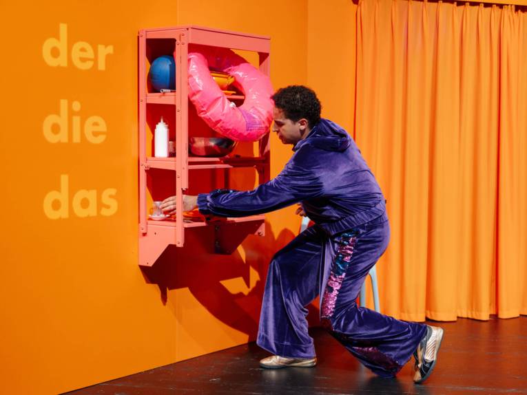 Ein Mann ordnet in einem Regel Dinge nach den Artikeln der, die und das.