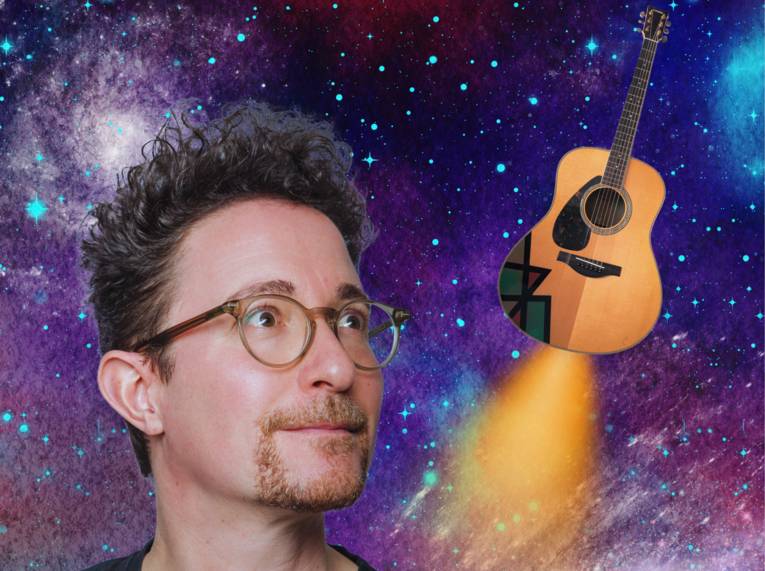 Porträt eines Mannes mit kurzem Haar, Bart und Brille, neben seinem Kopf eine Gitarre mit "Raketenantrieb"