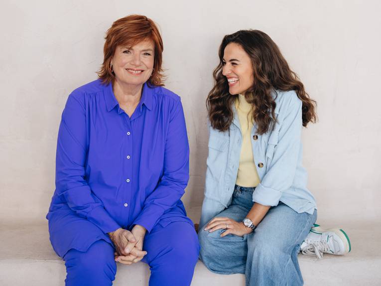 zwei Frauen sitzen und lachen miteinander