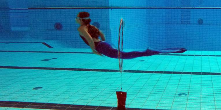 Eine Frau mit Meerjungfrauenschwimmanzug unter Wasser