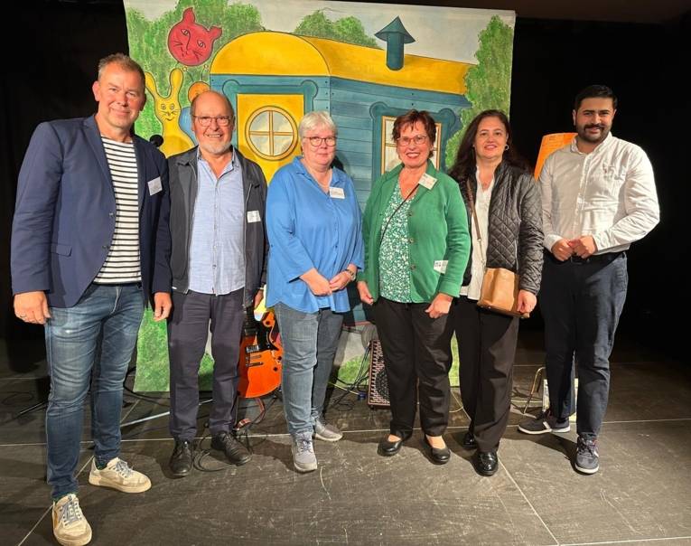 6 Personen stehen nebeneinander um fotografiert zu werden