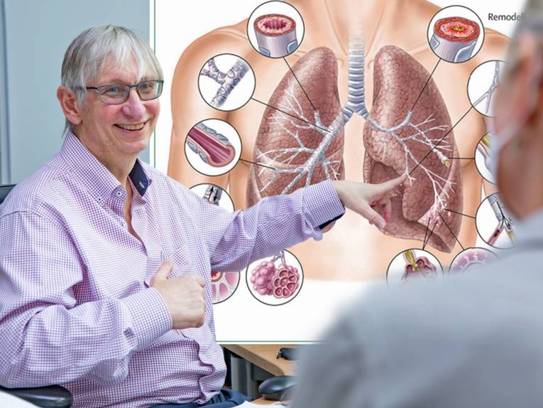 Ein Mann zeigt auf eine schematische Darstellung einer menschlichen Lunge.