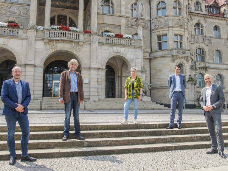 Fünf Personen auf der Treppe vor dem Neuen Rathaus