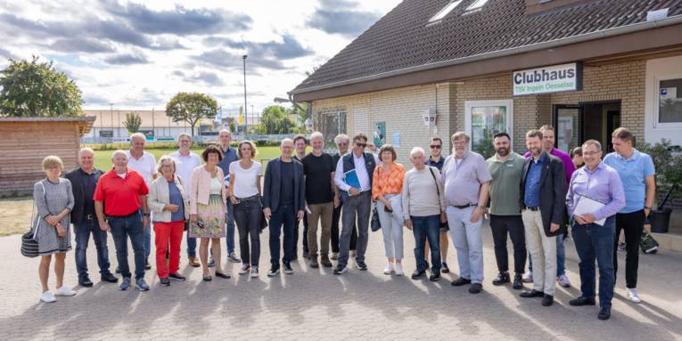 Gruppe von Personen vor einem Vereinsheim