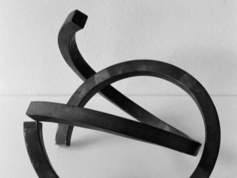 Zu sehen ist eine minimalistische Skulptur aus gebogenen, schwarzen Eisenstangen von Jan Meyer-Rogge.
