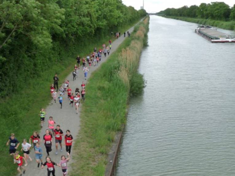 Menschen laufen in Sportkleidung entlang des Mittellandkanals