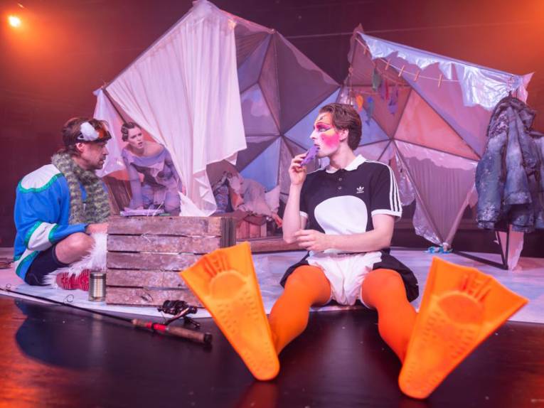 Zwei Schauspieler und eine Schauspielerin auf einer Bühne.