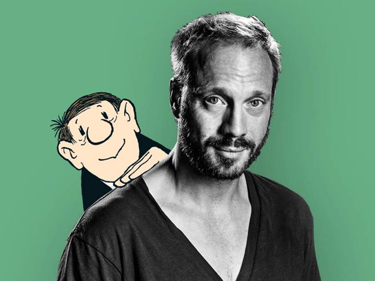 Eine gezeichnete Loriot-Figur sieht über der Schulter des Schauspielers Johann von Bülow