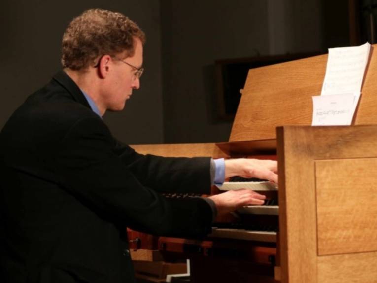 Zu sehen ist Prof. Thomas Lennartz an einer Orgel.