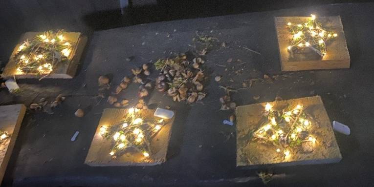 Mehrere gebastelte, leuchtende Sterne liegen auf einem Tisch.