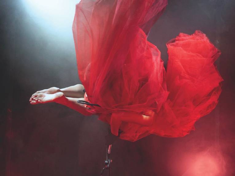 Eine Frau in einem roten Kleid auf einer Bühne