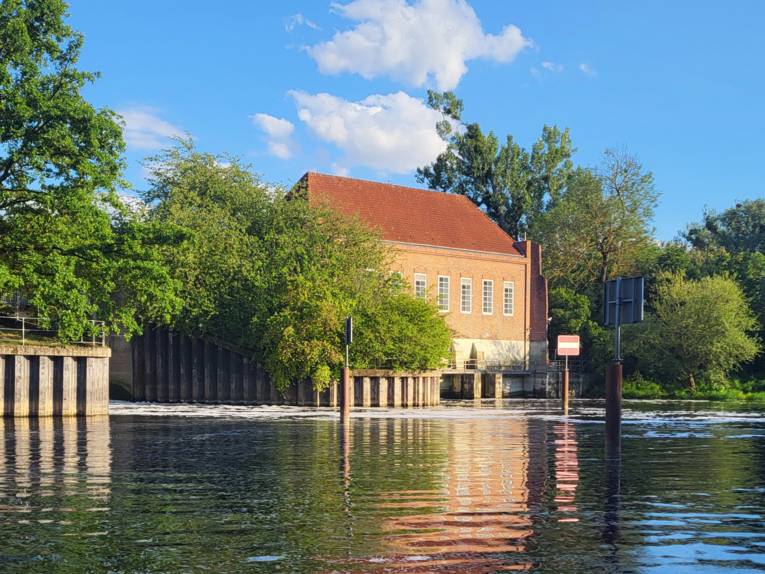 Ein Gebäude von außen. Davor Wasser.