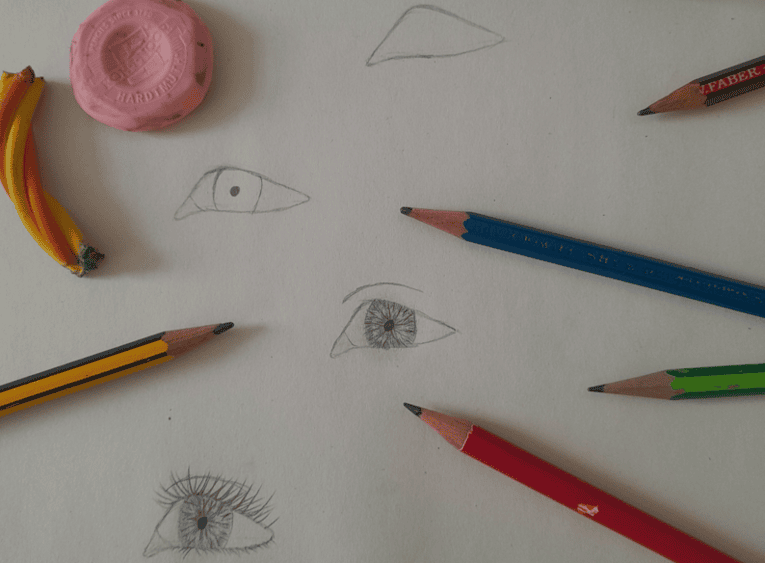 Ein schritt für schritt gezeichnetes Auge mit Stiften und anderen Zeichen Utensilien drum rum.