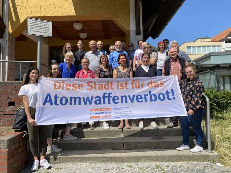 Bürgermeisterin Simone Maiwald präsentiert vor dem Meeboldhaus in der Stadt Heidenheim eine Flagge gegen Atomwaffen