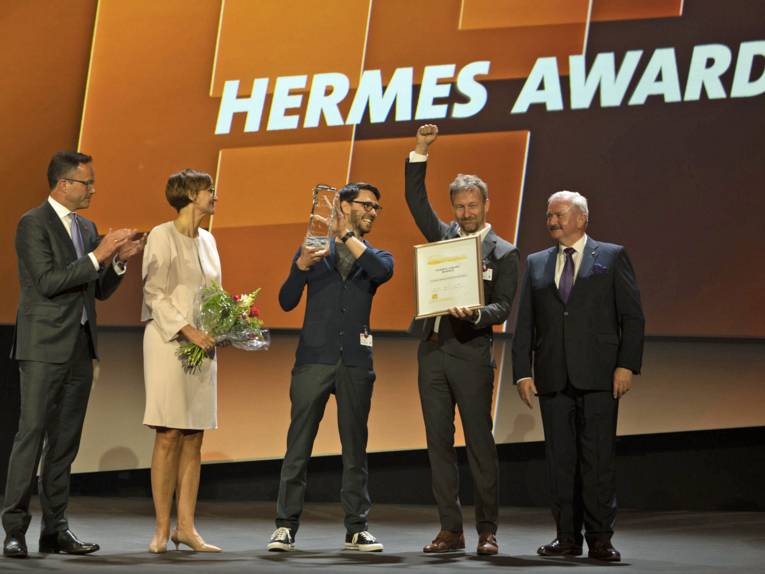 Bettina Stark-Watzinger, Bundesministerin für Bildung und Forschung, überreicht drei Herren den Hermes Award.