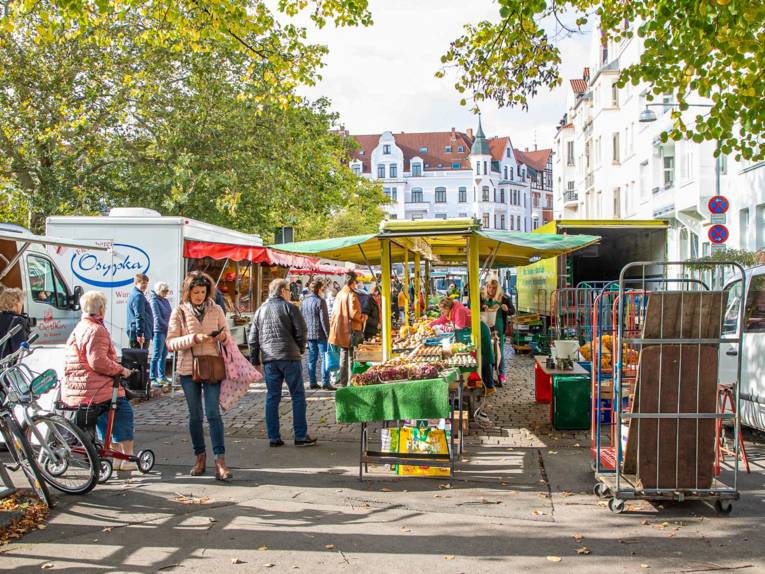 Menschen auf einem Wochenmarkt.