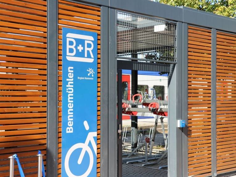Eingang eines überdachten Fahrrad-Abstellbereichs am S-Bahnhof, am Eingang steht: B+R Bennemühlen.