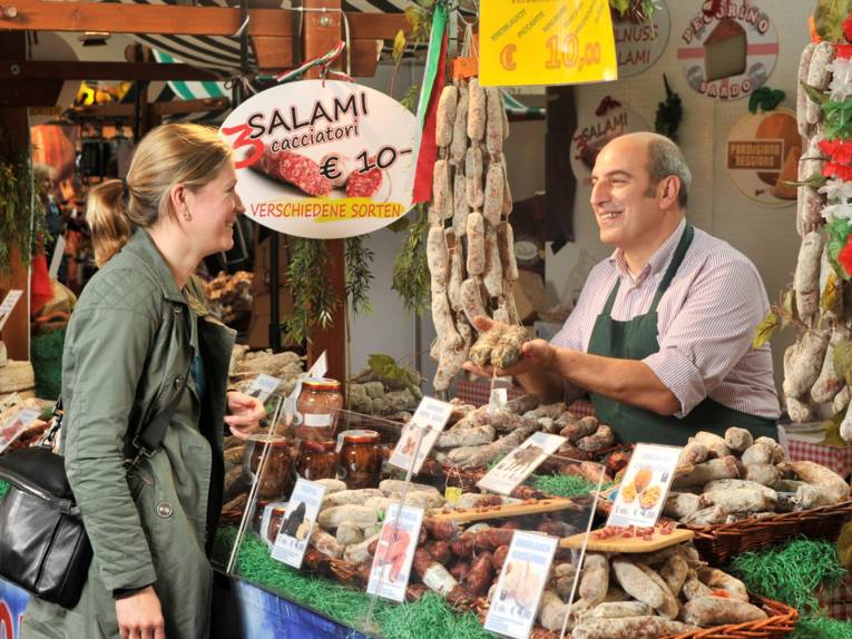 Frau und Mann an einem Salami-Verkaufsstand.