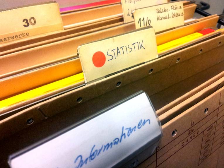 Diverse Sammelmappe in einer Schreibtischschublade, im Zentrum eine Mappe mit der Aufschrift "Statistik"