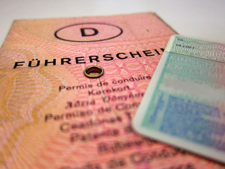 Ein alter deutscher Führerschein im Fokus, am Bildrand ein Teil eines EU-Kartenführerscheins