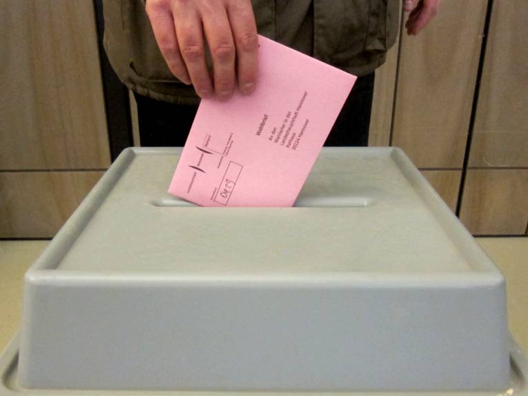 Einwurf von Wahlunterlagen in eine Wahlurne