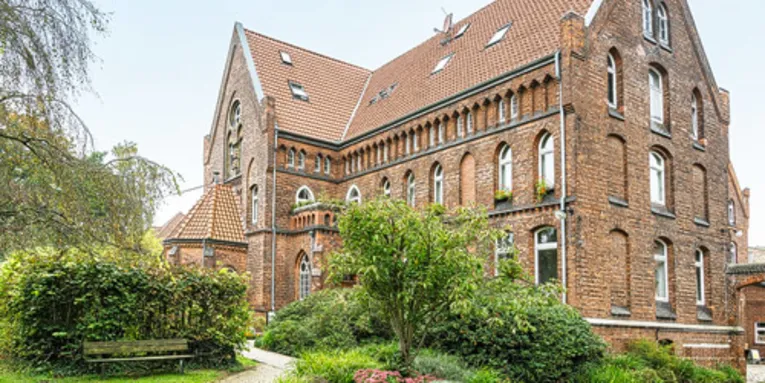Großes Backsteingebäude mit zwei Vollgeschossen und zwei Dachgeschossen.