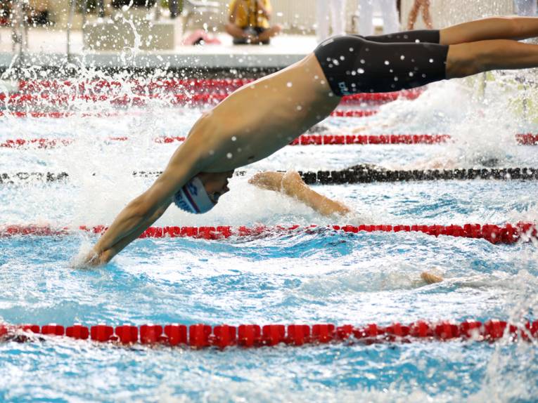 Schwimmer, der mit einem Kopfsprung ins Wasser springt