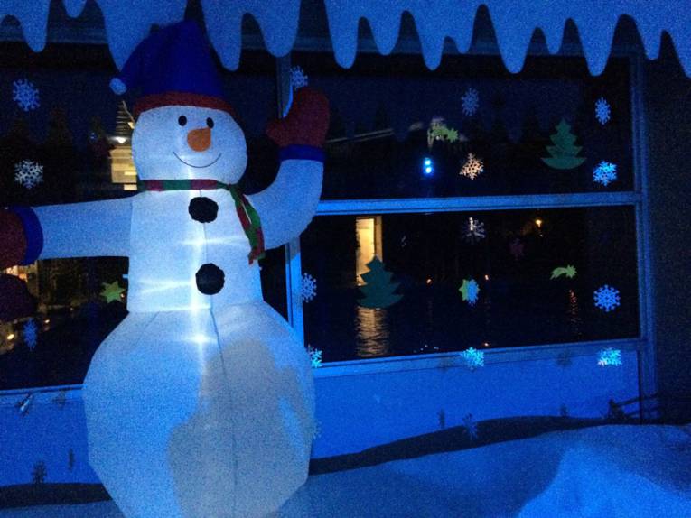 Ein Hallenbad von innen. Zu sehen ist eine weihnachtlich dekorierte Fensterfront und davor eine große Schneemannfigur.