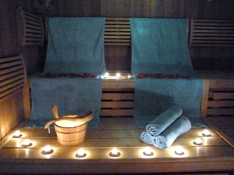 Sauna mit Handtüchern, Kerzen und Saunaeimer