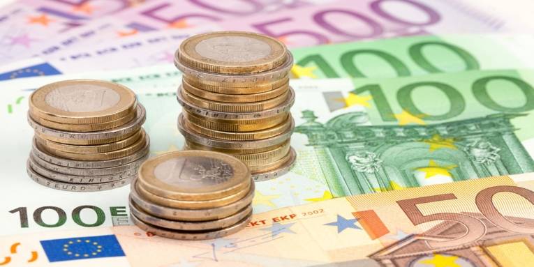 Mehrere Ein-Euromünzen auf drei 500 Euro, zwei 100 Euro und einem 50 Euro Schein