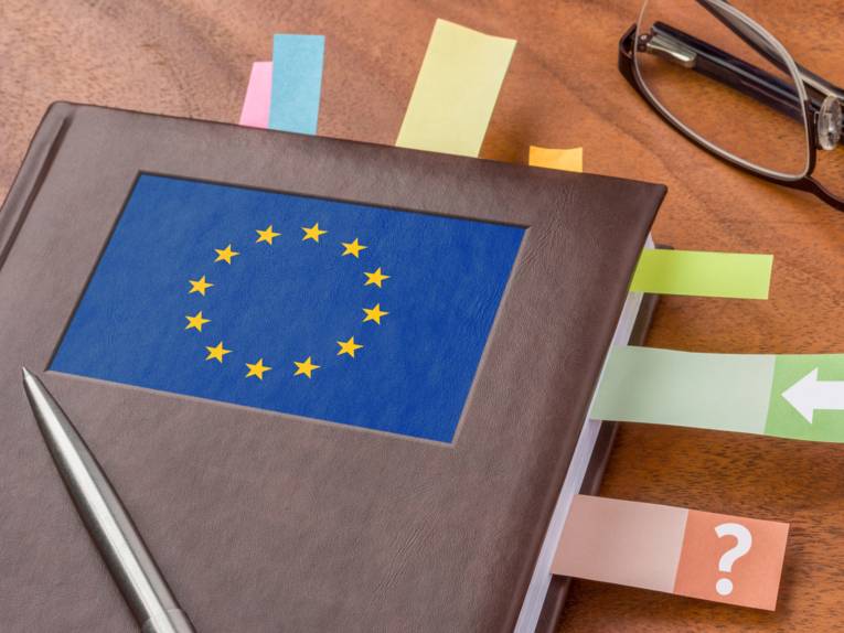 Geschäftsbuch mit der Flagge der EU und Post-its